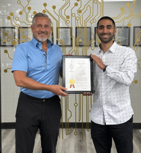 Onanon's latest magnetic connector patent, displayed by Dennis Johnson, General Manager, and Keyon Keshtgar, Sr. Design / Engineering Manager.